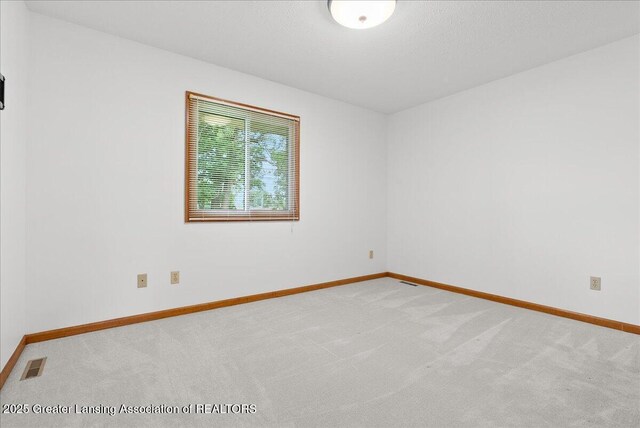 235 Bonnie Brook Dr Unit 1, Charlotte, MI 48813 - empty room featuring light colored carpet and baseboards