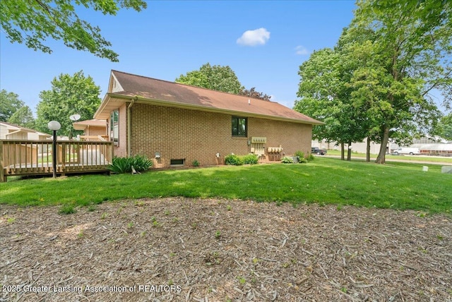235 Bonnie Brook Dr Unit 1, Charlotte, MI 48813 - view of home's exterior featuring brick siding, a deck, a yard, and crawl space