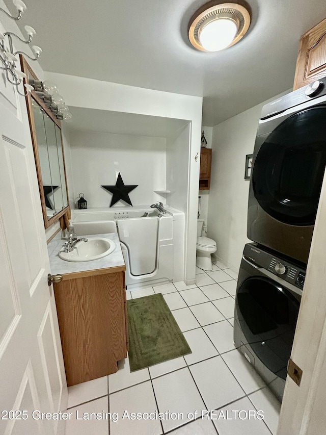 10497 Charlotte Hwy, Portland, MI 48875 - full bath with estacked washer and dryer, vanity, tile patterned floors, and a bath