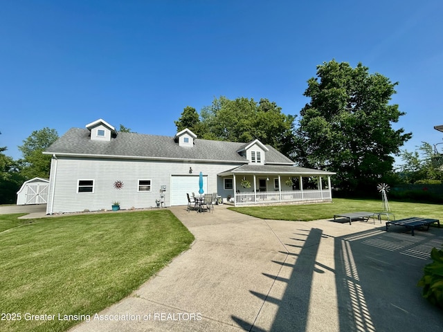 10497 Charlotte Hwy, Portland, MI 48875 - back of house with a porch, a yard, a garage, concrete driveway, and roof with shingles