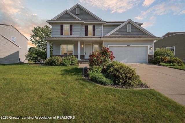 8687 Yellowstone Ln, Lansing, MI 48917 - view of front of property featuring concrete driveway, a garage, a porch, a yard, and stone siding