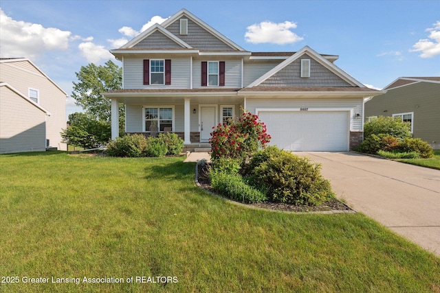 8687 Yellowstone Ln, Lansing, MI 48917 - view of front of home with a garage, concrete driveway, a front yard, a porch, and stone siding