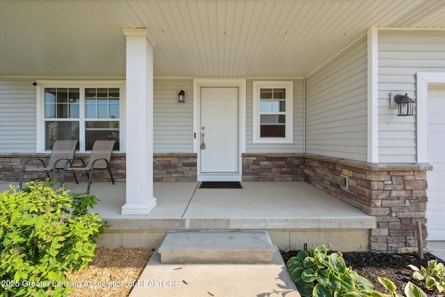 8687 Yellowstone Ln, Lansing, MI 48917 - doorway to property with covered porch and stone siding
