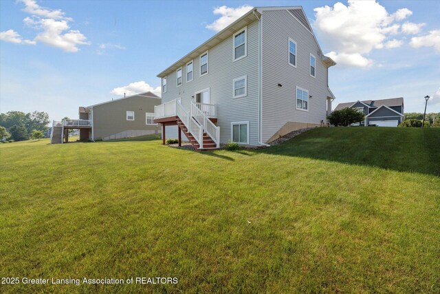 8687 Yellowstone Ln, Lansing, MI 48917 - back of property with stairs, a yard, and a deck