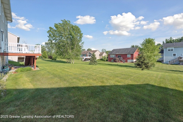 8687 Yellowstone Ln, Lansing, MI 48917 - view of grassy yard with a wooden deck and a residential view