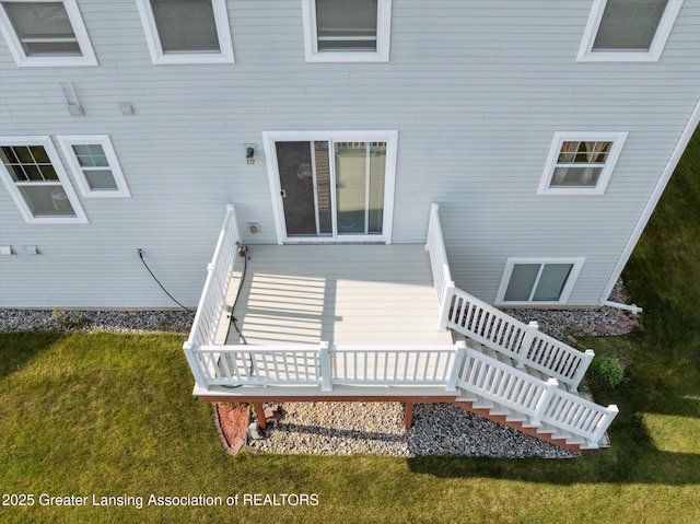 8687 Yellowstone Ln, Lansing, MI 48917 - back of property featuring stairway, a lawn, and a deck