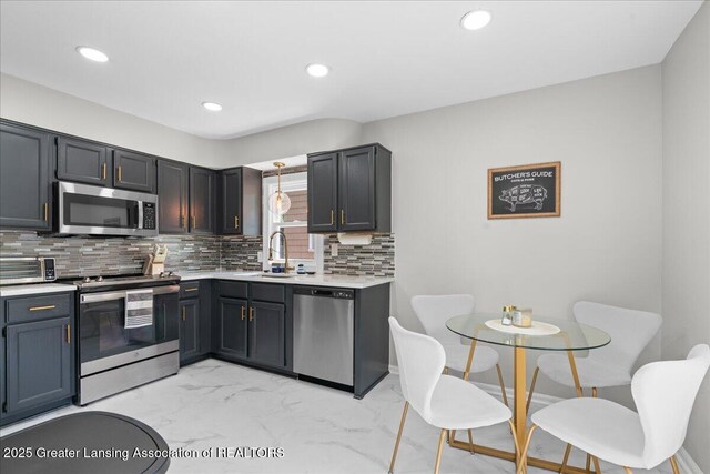 952 Sunset Ln, East Lansing, MI 48823 - kitchen with appliances with stainless steel finishes, light marble finish flooring, light countertops, decorative backsplash, and recessed lighting
