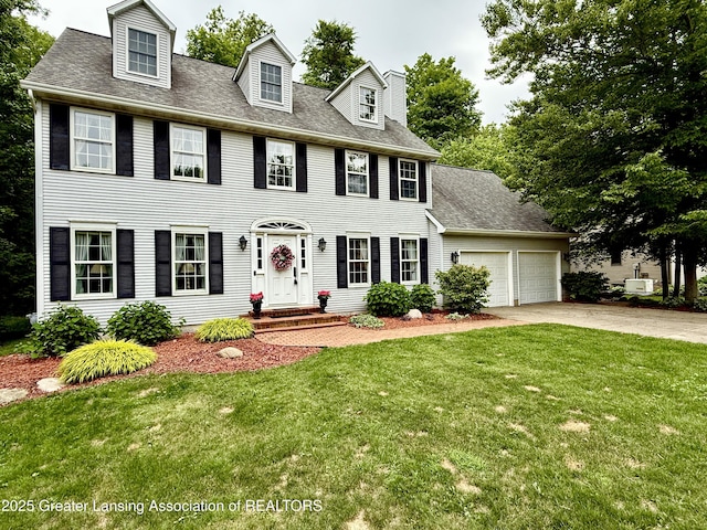 1204 Burlington Dr, Grand Ledge, MI 48837 - colonial-style house with driveway, an attached garage, a front lawn, and a shingled roof