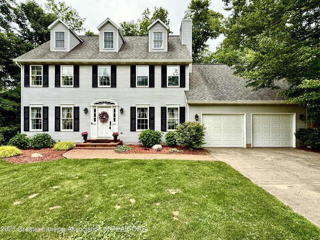 1204 Burlington Dr, Grand Ledge, MI 48837 - colonial home with driveway, an attached garage, a front lawn, a chimney, and a shingled roof