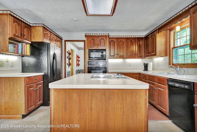 1204 Burlington Dr, Grand Ledge, MI 48837 - kitchen featuring black appliances, a center island, light countertops, and brown cabinetry
