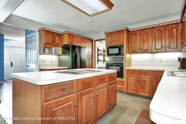 1204 Burlington Dr, Grand Ledge, MI 48837 - kitchen featuring black appliances, a kitchen island, light countertops, and brown cabinetry