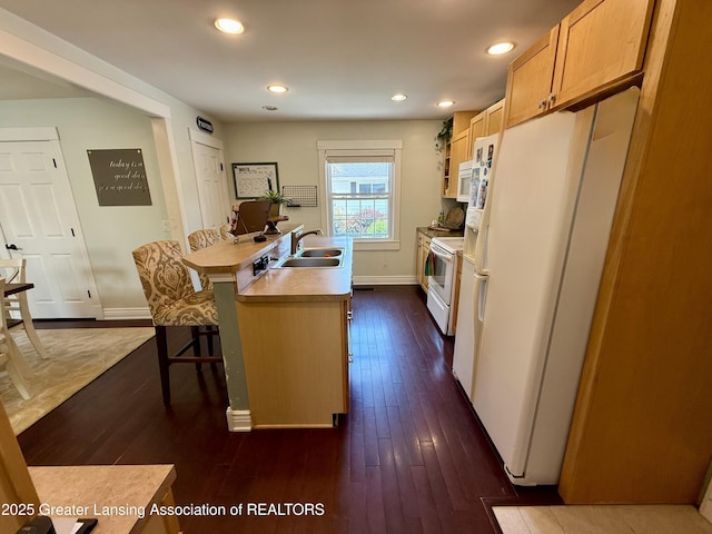 3321 Springbrook Ln, Lansing, MI 48917 - kitchen with white appliances, dark wood finished floors, light countertops, a kitchen breakfast bar, and an island with sink