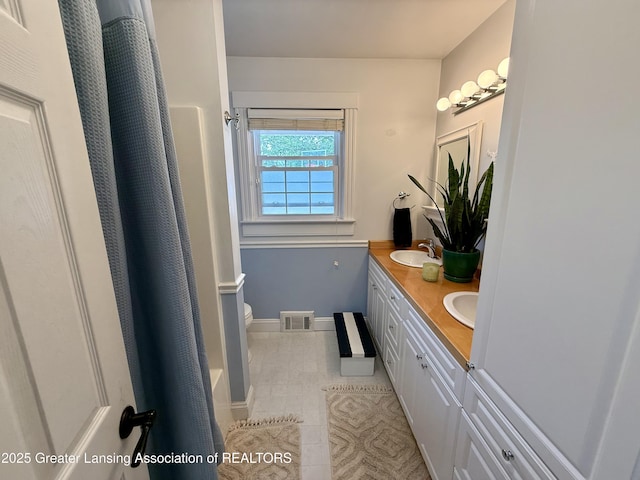 3321 Springbrook Ln, Lansing, MI 48917 - bathroom with double vanity, tile patterned flooring, and a shower with curtain