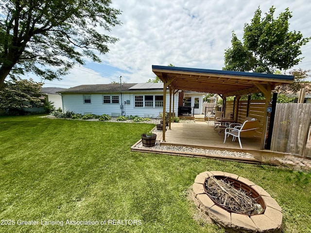 3321 Springbrook Ln, Lansing, MI 48917 - rear view of house with a fire pit, a deck, and solar panels