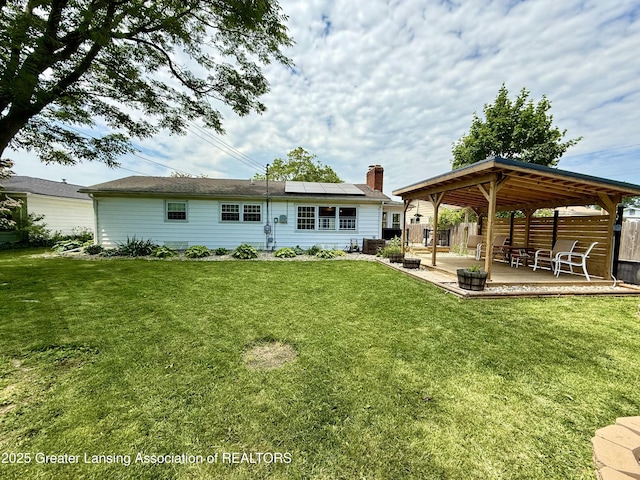 3321 Springbrook Ln, Lansing, MI 48917 - back of property with solar panels, a patio, a gazebo, and a chimney