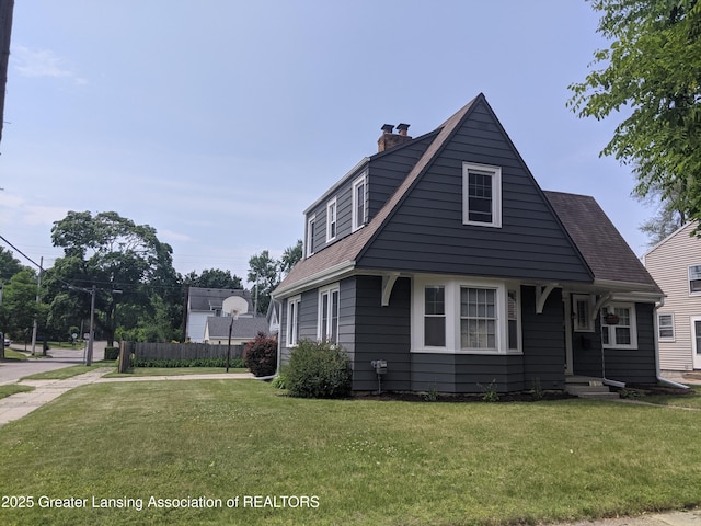 542 Riley St, Lansing, MI 48910 - view of front facade featuring a chimney and a front yard
