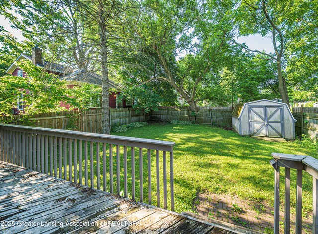 1407 W Ionia St, Lansing, MI 48915 - wooden deck featuring a fenced backyard and a storage unit