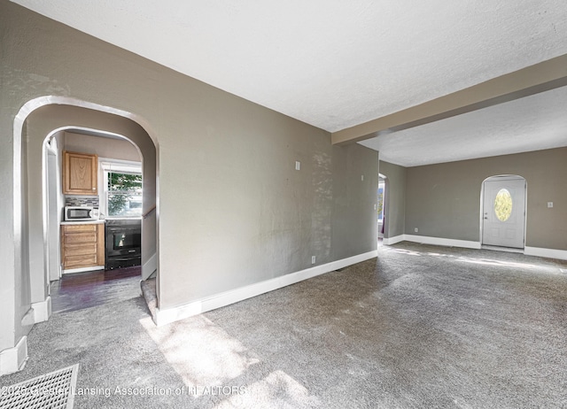 1407 W Ionia St, Lansing, MI 48915 - empty room with arched walkways, carpet floors, and a textured ceiling