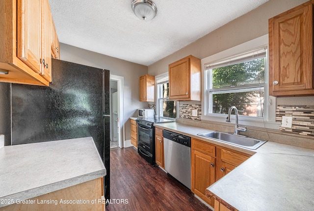 1407 W Ionia St, Lansing, MI 48915 - kitchen featuring black appliances, light countertops, dark wood-style flooring, decorative backsplash, and a textured ceiling