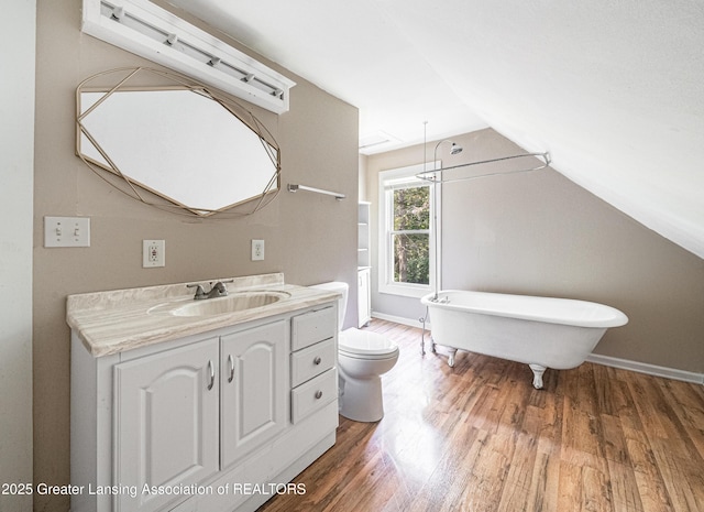 1407 W Ionia St, Lansing, MI 48915 - bathroom with a soaking tub, wood finished floors, vaulted ceiling, and vanity