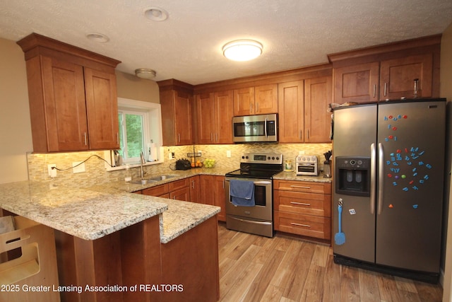 8522 Ember Glen Pass, Lansing, MI 48917 - kitchen featuring stainless steel appliances, a peninsula, brown cabinetry, and light stone countertops