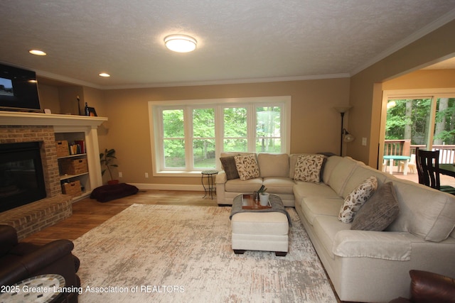 8522 Ember Glen Pass, Lansing, MI 48917 - living room with healthy amount of natural light, wood finished floors, a brick fireplace, crown molding, and recessed lighting