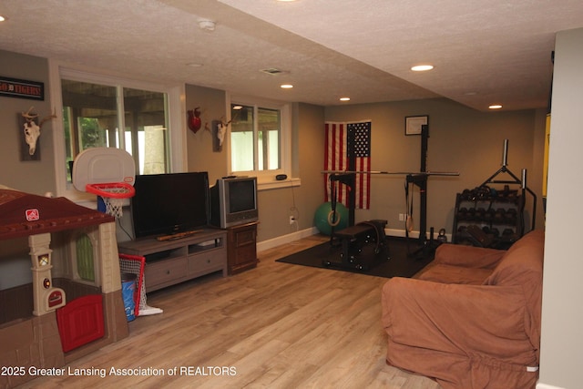 8522 Ember Glen Pass, Lansing, MI 48917 - living room with wood finished floors, recessed lighting, plenty of natural light, and a textured ceiling