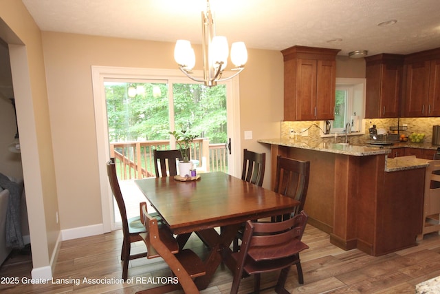 8522 Ember Glen Pass, Lansing, MI 48917 - dining area with light wood-style floors and a chandelier