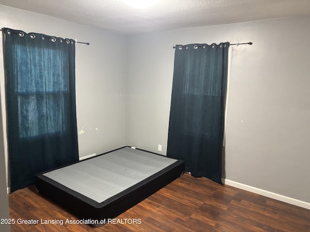 1311 W Saginaw St, East Lansing, MI 48823 - unfurnished bedroom featuring wood finished floors and baseboards