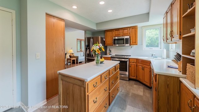 3522 Apple Valley Rd, Okemos, MI 48864 - kitchen with stainless steel appliances, light countertops, a center island, open shelves, and brown cabinetry