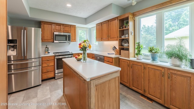 3522 Apple Valley Rd, Okemos, MI 48864 - kitchen featuring appliances with stainless steel finishes, light countertops, brown cabinets, and recessed lighting