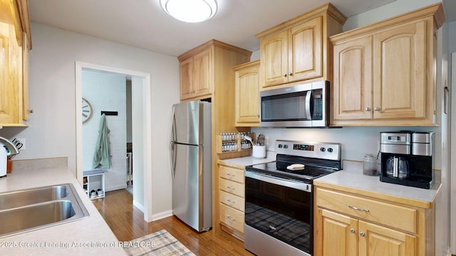 6916 Toboggan Ln, Lansing, MI 48917 - kitchen with stainless steel appliances, light brown cabinetry, wood finished floors, and light countertops