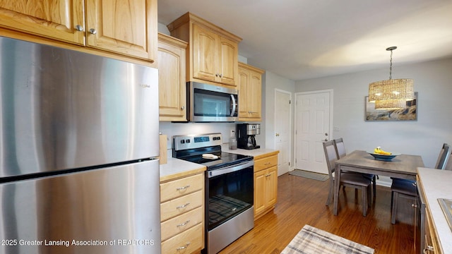 6916 Toboggan Ln, Lansing, MI 48917 - kitchen with stainless steel appliances, light brown cabinets, light countertops, and wood finished floors