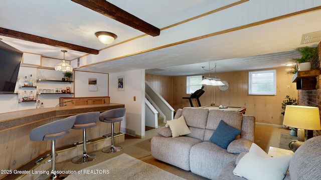 6916 Toboggan Ln, Lansing, MI 48917 - living room with beam ceiling, wooden walls, bar, carpet floors, and stairway