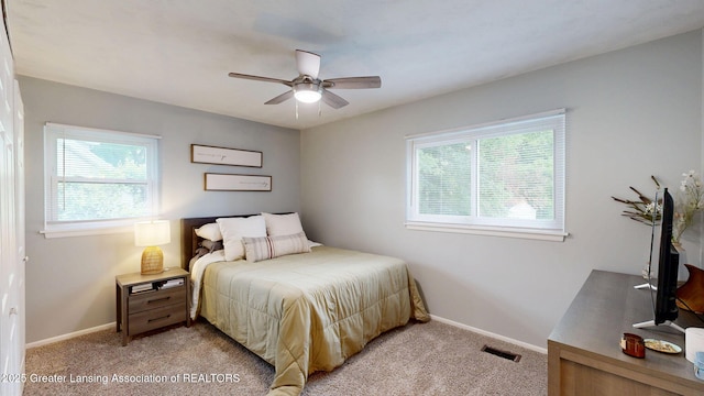 6916 Toboggan Ln, Lansing, MI 48917 - bedroom with multiple windows, light colored carpet, and ceiling fan