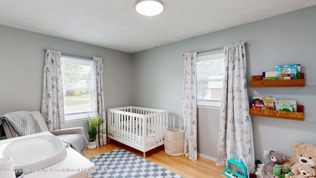 6916 Toboggan Ln, Lansing, MI 48917 - bedroom with wood finished floors and a crib