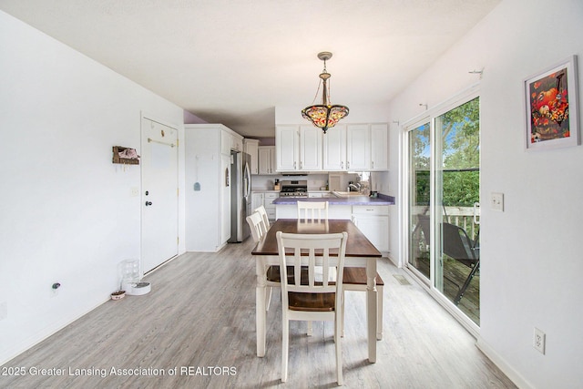6093 Anchor Cv, Dimondale, MI 48821 - dining space with light wood finished floors and a chandelier