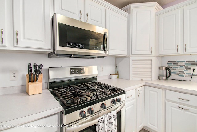 6093 Anchor Cv, Dimondale, MI 48821 - kitchen with appliances with stainless steel finishes, white cabinetry, and decorative backsplash