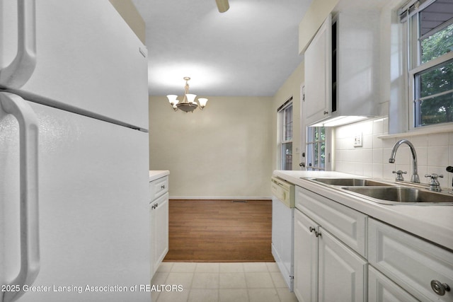6213 Beechfield Dr, Lansing, MI 48911 - kitchen featuring white appliances, a chandelier, tasteful backsplash, white cabinetry, and light countertops
