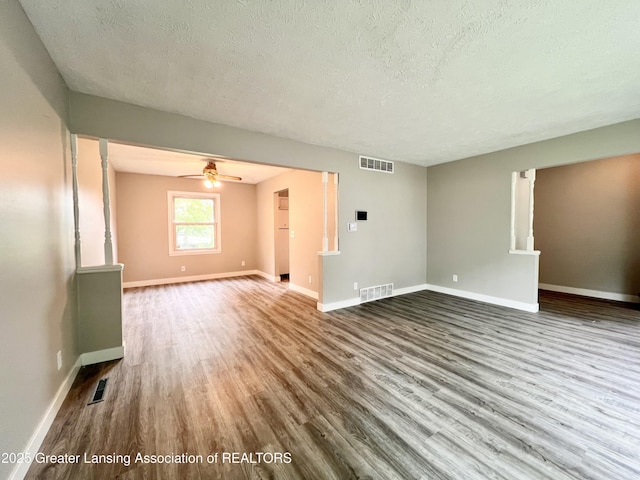 5401 Catalpa Dr, Lansing, MI 48911 - unfurnished living room with a textured ceiling, wood finished floors, and ceiling fan