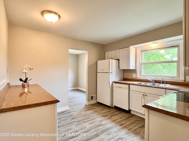 5401 Catalpa Dr, Lansing, MI 48911 - kitchen featuring white appliances, light wood-type flooring, white cabinets, and dark countertops