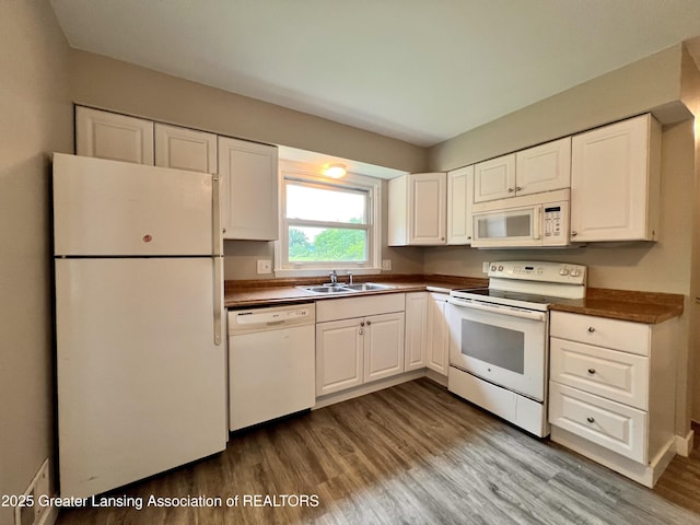 5401 Catalpa Dr, Lansing, MI 48911 - kitchen with white appliances, dark countertops, wood finished floors, and white cabinetry