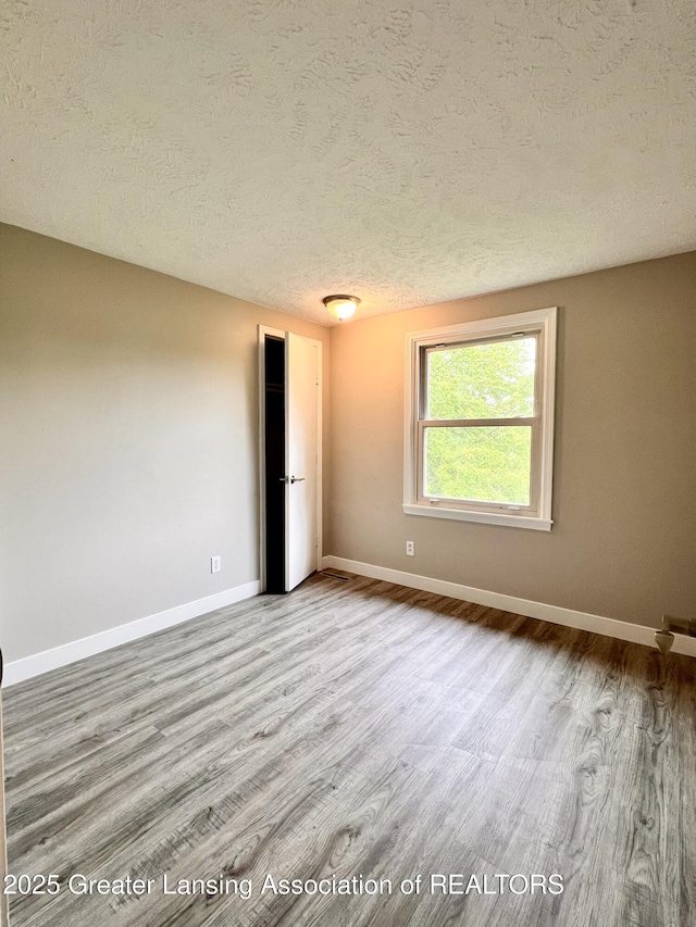 5401 Catalpa Dr, Lansing, MI 48911 - empty room featuring wood finished floors and a textured ceiling