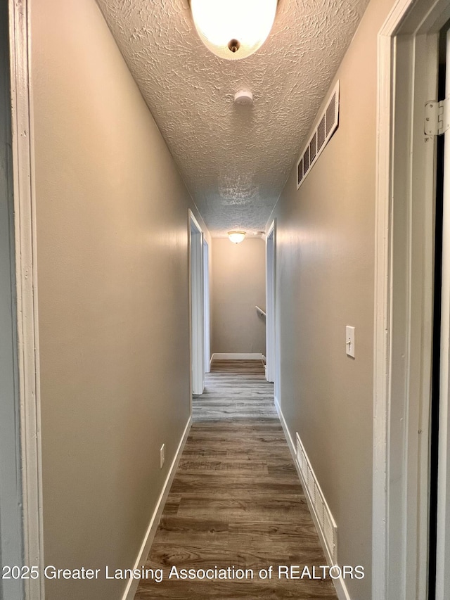 5401 Catalpa Dr, Lansing, MI 48911 - hallway featuring a textured ceiling and dark wood-type flooring