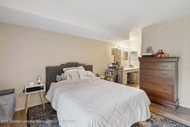 1457 E Pond Dr Unit 21, Okemos, MI 48864 - bedroom featuring wood finished floors and connected bathroom
