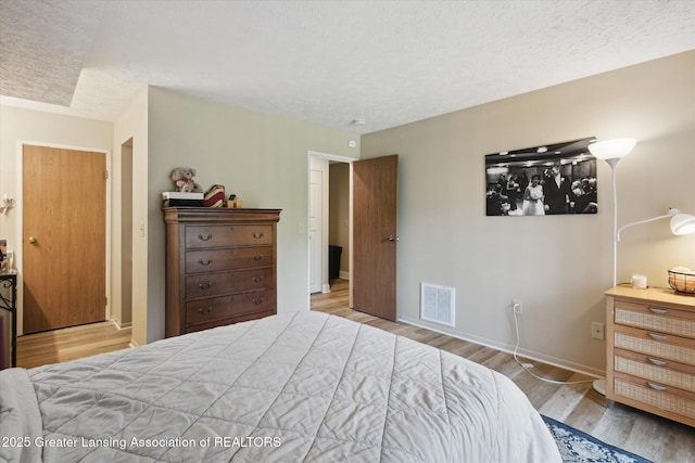 1457 E Pond Dr Unit 21, Okemos, MI 48864 - bedroom featuring wood finished floors and a textured ceiling