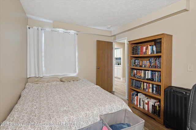1457 E Pond Dr Unit 21, Okemos, MI 48864 - bedroom featuring wood finished floors and a textured ceiling