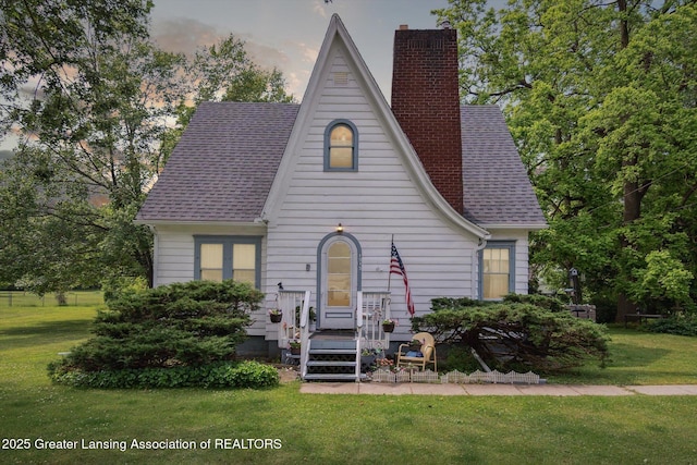 1213 N Woodworth Rd, Jackson, MI 49202 - english style home with a chimney, a front lawn, and roof with shingles
