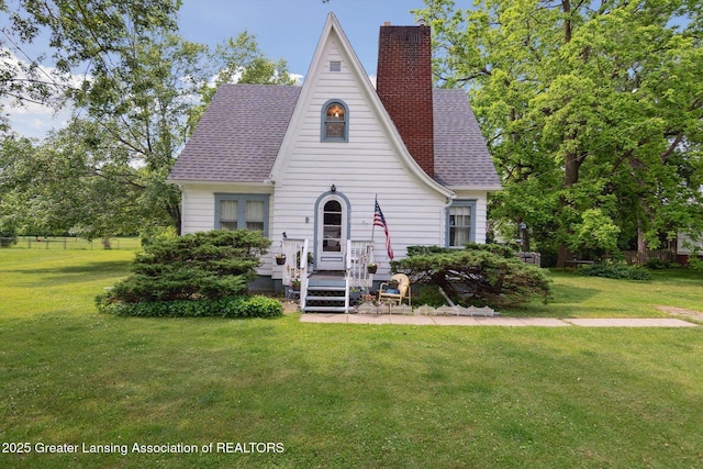 1213 N Woodworth Rd, Jackson, MI 49202 - tudor home featuring a chimney, a front yard, and roof with shingles