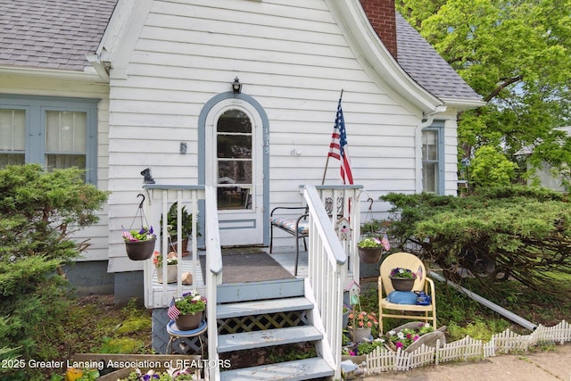 1213 N Woodworth Rd, Jackson, MI 49202 - view of exterior entry with a shingled roof and a chimney